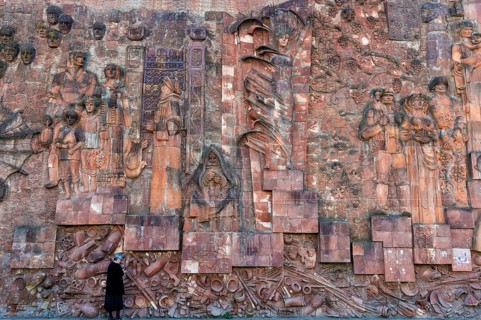 Close-up of faces from communist era on facade of city market