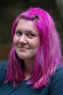 Portrait of a young woman with freckles and pink