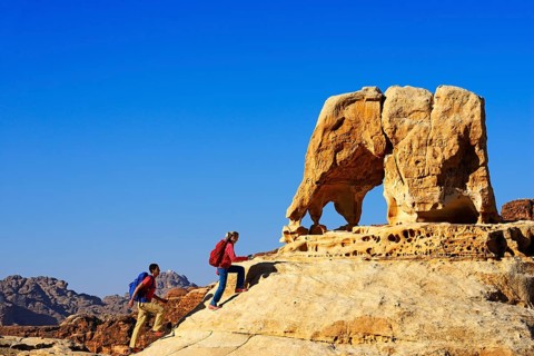 Hikers climb Elephant Rock outside of Petra