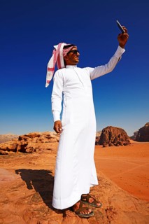 Bedouin uses his smartphone at Rock Arch