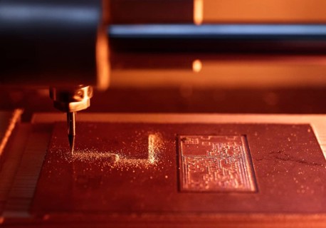 CNC machine milling conductor paths for electronic circuit in copper plate