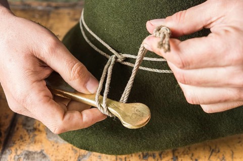 Tightening the shaping cord around a wool felt hat