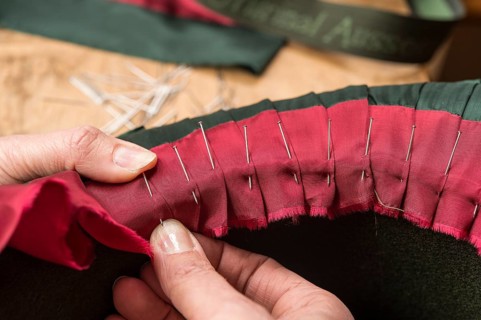 Hands folding and fastening silk ribbon using pins