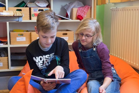 Two students in elementary school reading a book