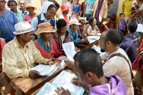 Villagers fill out applications for certification of their land on the village square
