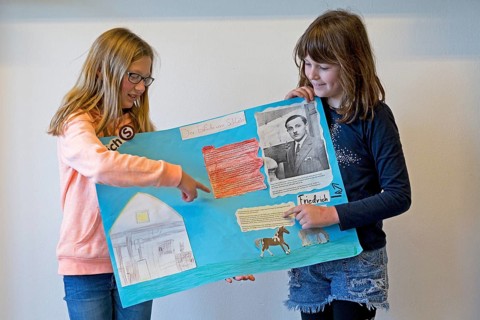 Two students with poster giving a presentation