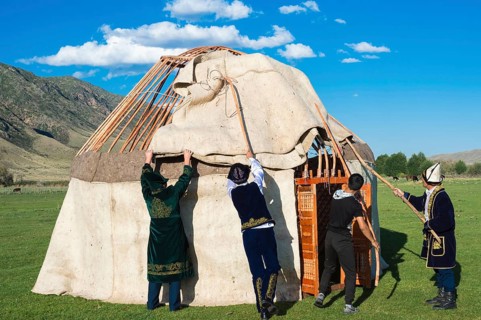 Kazakh men putting up a yurt