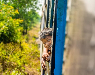 Small local boy looking out of moving train