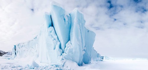 Iceberg seen from frozen fjord