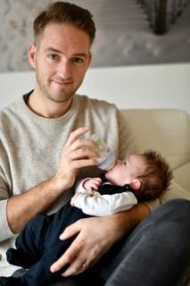 Young father feeding infant