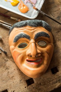 Painted wooden mask on a workbench