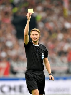 Referee Christian Dingert displays yellow card