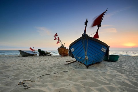Fishing boats on beach at sunrise
