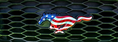 Horse figure in colors of the USA flag on grille of a Ford Mustang car