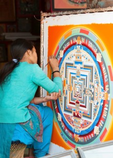 Female artist working on a mandala in a local handicraft shop