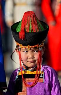 Little girl in traditional Deel clothes and hat with cone-shaped lace
