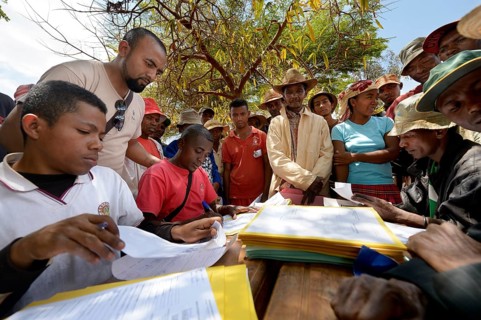 Villagers fill out applications for certification of their land on the village square