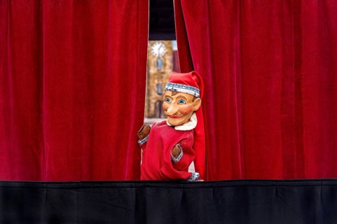 Puppet looking through curtain