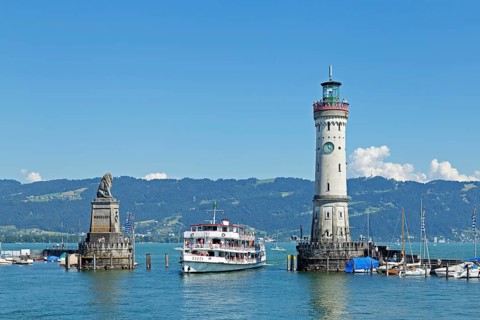 Passenger ship in port entrance with lighthouse in the harbor