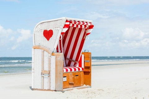 Beach chair with red heart on the beach