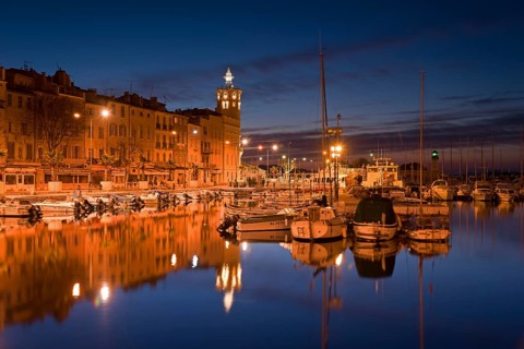 Old city with boats in the harbour at night