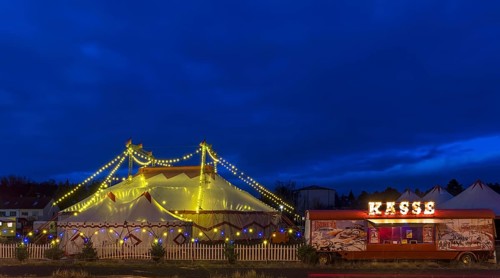Travelling circus with counter illuminated at dusk