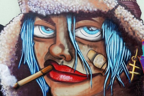 Face of a woman with cigarette and bandaid on cheek