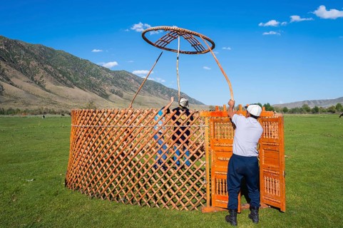 Kazakh men putting up a yurt