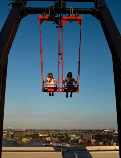 Children sway in the Swing 'Over The Edge high above the rooftops of Amsterdam on the A'DAM LOOKOUT