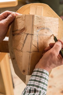 Drawing the outline of a face on a wooden block