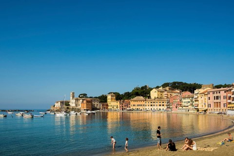 People on the beach in the bay Baia del Silenzio