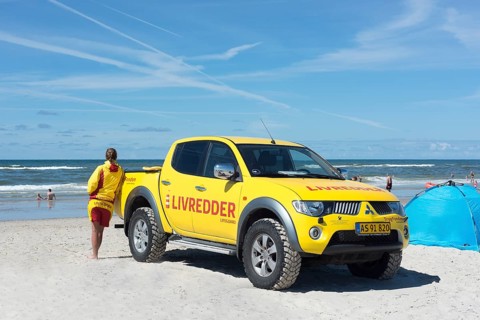 Yellow car with inscription Livredder on Henne Beach