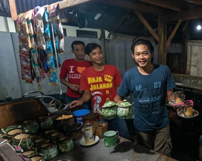 Native waiter offering tea from booth