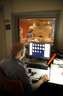 Doctor monitoring computer radiographs of MRI machine