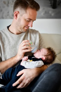 Young father feeding infant