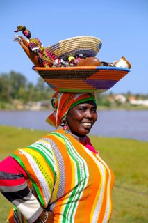 Senegalese woman in colorful dress with goods on her head