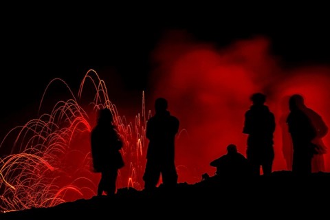 Tourists observe the eruption