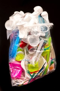 Garbage bag filled with disposable crockery