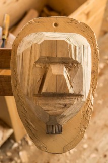 Partially shaped wooden block fixed on a workbench
