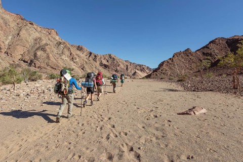 Hikers in dry riverbed