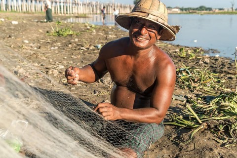Fisherman mending his net Taungthaman Lake