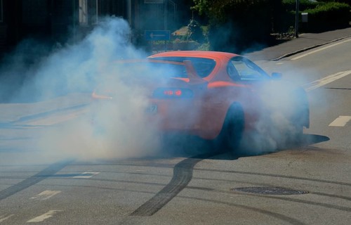 Car burning tire on a street