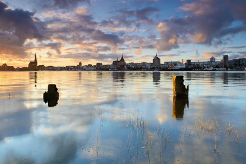 Old town and city harbour reflected in the river Warnow