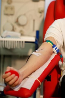 Patient with an infusion needle taking a blood sample at the transfusion ward of a hospital