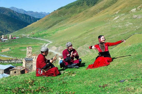 Georgian people of a folkloric group playing Panduri and dancing in traditional Georgian clothes