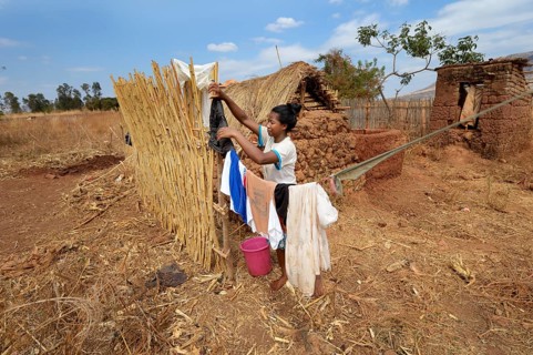 Woman hangs wet clothes on a clothes line