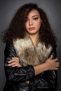 Young woman with curly hair in black jacket