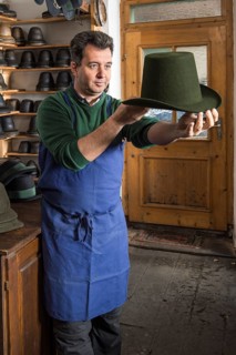 Hatter examining finished wool felt hat