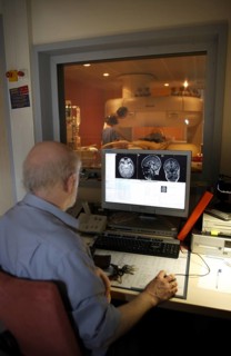 Doctor monitoring computer radiographs of MRI machine