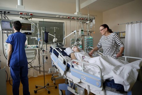 Child in hospital bed with mother in the ICU